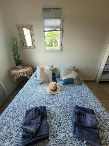 une chambre avec un lit avec un chapeau dessus dans l'établissement Maison entre vignes et piscine à 5 mn des plages !, à Saint-Cyr-sur-Mer