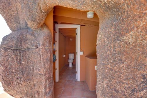 una vista de un baño a través de una gran puerta de piedra en Pool with Slide and Playground Arizona Group Getaway!, en Apache Junction