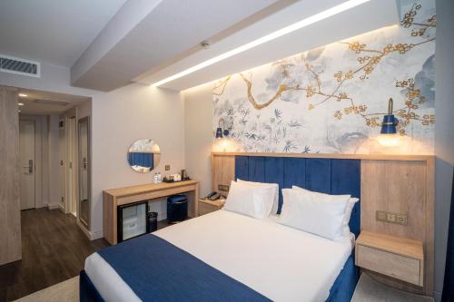 a bedroom with a bed and a painting on the wall at Querencia Hotel in Istanbul