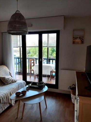 un salon avec un canapé et une table dans l'établissement Appartement cosy proche mer, à Villers-sur-Mer