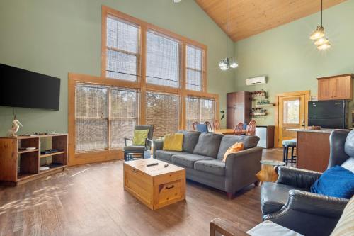 a living room with a couch and a tv at Pool Retreat Waterfront 6 Bedroom Boat Ramp Game Room Pass Christian Home in Pass Christian