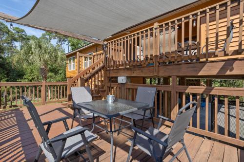 a patio with a table and chairs on a deck at Pool Retreat Waterfront 6 Bedroom Boat Ramp Game Room Pass Christian Home in Pass Christian