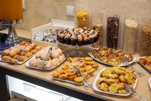 a buffet filled with different types of pastries and desserts at America Diamonds Hotel in Lisbon