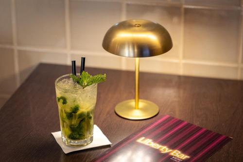 a drink sitting on a table next to a lamp at America Diamonds Hotel in Lisbon