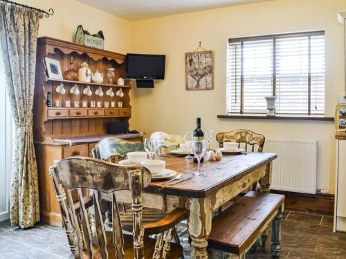 a dining room with a wooden table and chairs at Eastfield Cottage Free Parking And Ev Charger in Leven