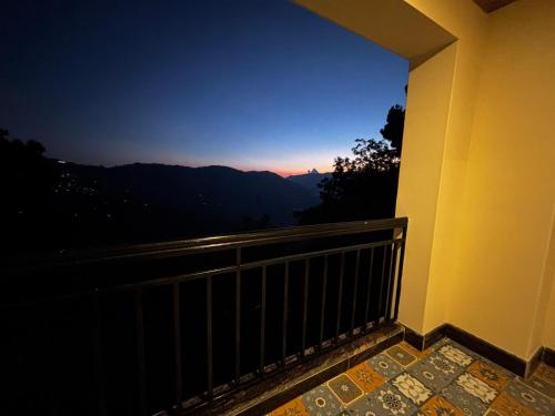 a balcony with a view of the mountains at night at Asraya Homestay in Darjeeling