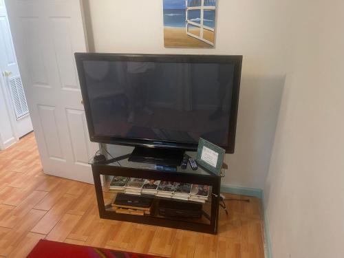 a flat screen tv on a stand in a room at 2BR Comfortable Downtown House Near Beach and More in West Palm Beach
