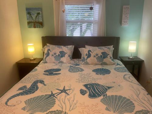 a bed in a bedroom with two lamps on tables at 2BR Comfortable Downtown House Near Beach and More in West Palm Beach