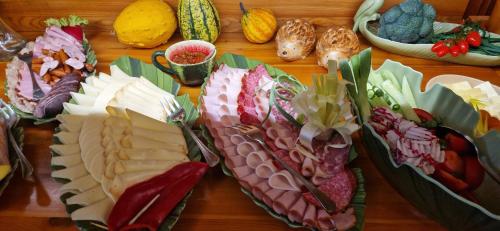 a table topped with plates of meats and vegetables at Brzozowa Osada - Premium Chalets Zakopane in Zakopane