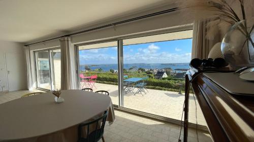 un salon avec une table et une grande fenêtre dans l'établissement Maison KER TITOU., à Ploubazlanec