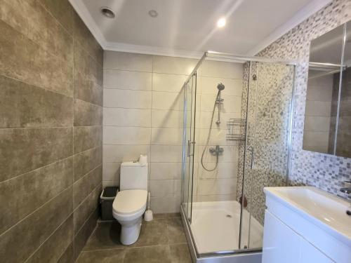 Un baño con inodoro, ducha y lavabo. en Botanical Garden Park Apartment, en Chişinău