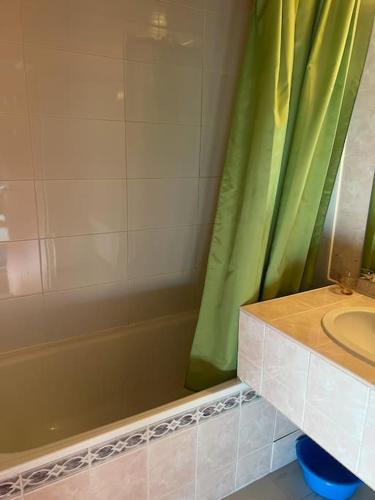 a bathroom with a green shower curtain and a sink at Centre Station 6 personnes in Val Thorens