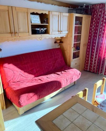 une chambre avec un lit rouge dans une pièce dans l'établissement Centre Station 6 personnes, à Val Thorens