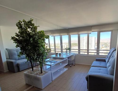 a living room with a table and a potted plant at Para negocios in Calama