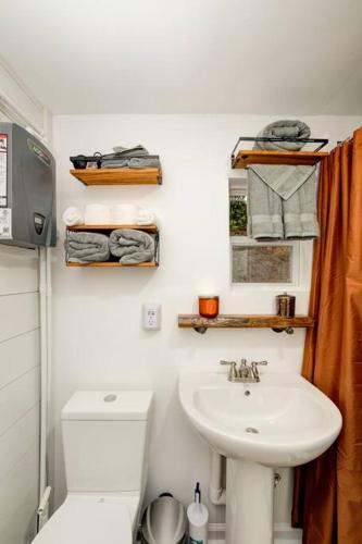 a white bathroom with a sink and a toilet at Sleeps 5-6 Near RRG-Hot Tub-Nice Sunrise-Quiet in Beattyville