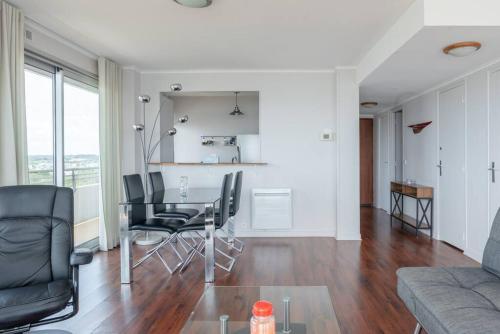 une salle à manger et un salon avec une table et des chaises dans l'établissement Sky baulois - Exceptionnel - vue mer - parking, à La Baule