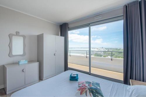 une chambre avec un lit et une grande fenêtre dans l'établissement Sky baulois - Exceptionnel - vue mer - parking, à La Baule