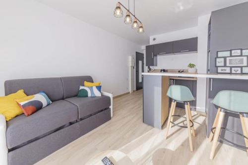 un salon avec un canapé et une cuisine dans l'établissement Le Studio Gare, à Rennes