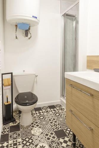 La salle de bains est pourvue de carrelage noir et blanc et de toilettes. dans l'établissement Le Studio Gare, à Rennes