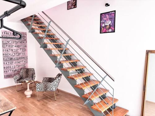 a staircase with glass railings in a living room at ThinkPink! Apartment im Herzen Dortmunds in Dortmund
