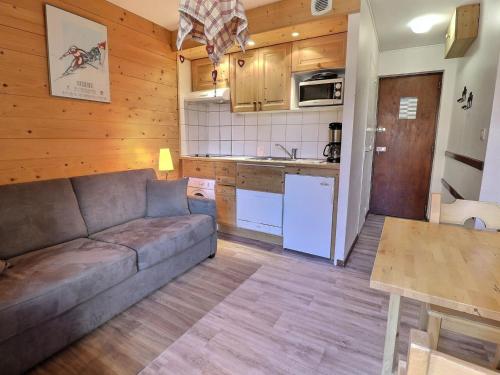 un salon avec un canapé et une cuisine dans l'établissement Studio skis aux pieds, bien équipé avec Wi-Fi – Les Allues - FR-1-182-42, à Méribel