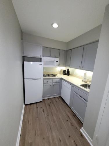a kitchen with white cabinets and a white refrigerator at Aksarben Gem-Easy access to I-80 in Omaha