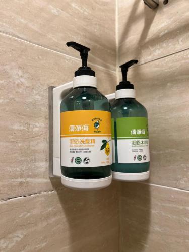 two bottles of cleaning products sitting on a wall at Mu-In Hotel in Kaohsiung