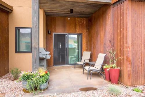 a patio with two chairs and a table and some plants at 57 Robber's Roost in Moab