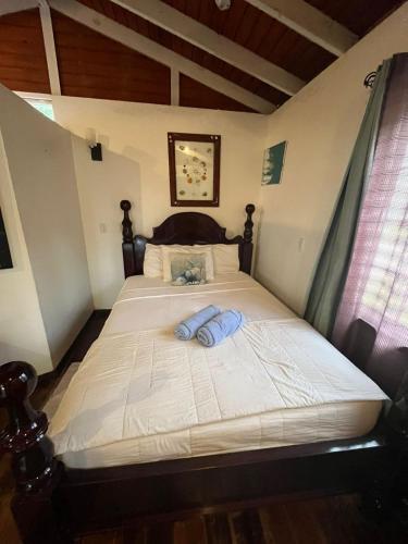 a bed with two blue towels sitting on it at Seaside Chateau Resort in Belize City