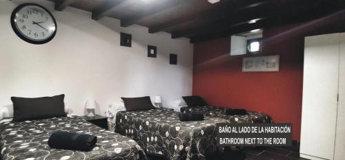 a room with two beds and a clock on the wall at Casa Das Airas in Sarria