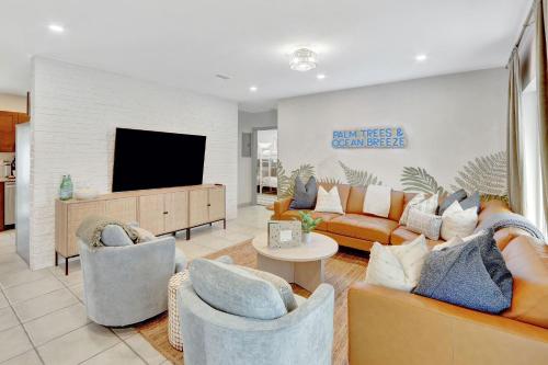 a living room with couches and a flat screen tv at Sunset Oasis with Movie Theatre, Heated Pool & Game Room in Pompano Beach