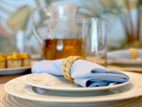 a table with a plate with a napkin and a napkin at Sunset Oasis with Movie Theatre, Heated Pool & Game Room in Pompano Beach