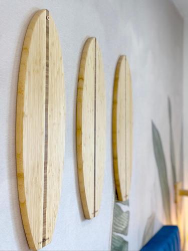 three wooden surfboards are hanging on a wall at Sunset Oasis with Movie Theatre, Heated Pool & Game Room in Pompano Beach