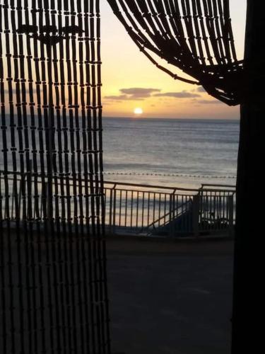 a view of the ocean from a window of a beach at Casa cueva primera línea playa in Gáldar