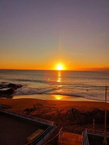 a sunset on a beach with the ocean at Casa cueva primera línea playa in Gáldar