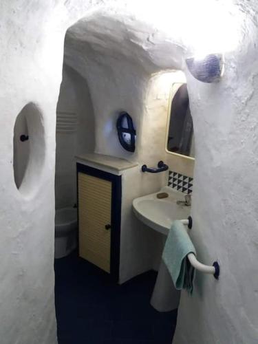 a small bathroom with a sink and a mirror at Casa cueva primera línea playa in Gáldar
