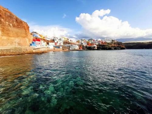 a view of a body of water with a city at Casa cueva primera línea playa in Gáldar