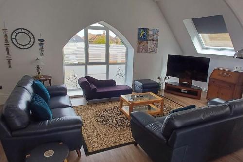 シャンクリンにあるThe Old School Hallのリビングルーム(黒革の家具、薄型テレビ付)