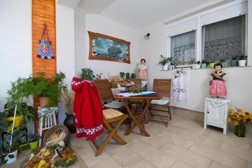 two dolls are standing in a room with a table and chairs at Apartman Žurić in Vinkovci