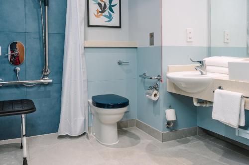 a bathroom with a toilet and a sink at voco Winchester Hotel & Spa by IHG in Winchester