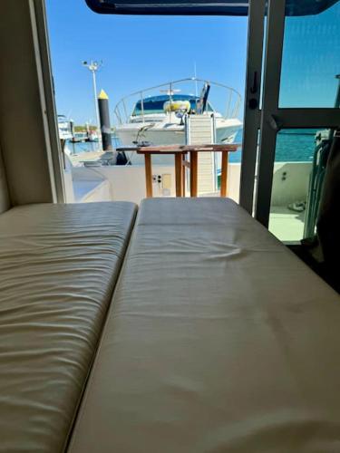 a bed on a boat with a table and a boat at Barco apartamento in El Portil