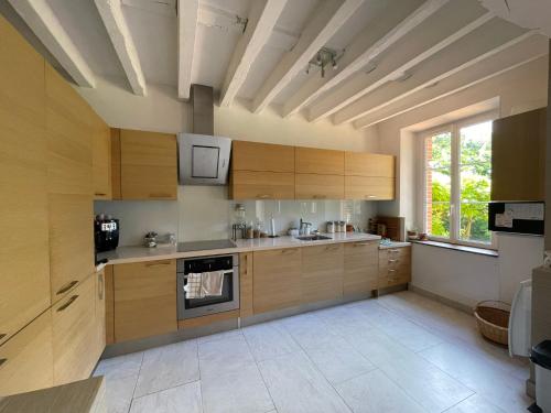 une cuisine avec des placards en bois et une grande fenêtre dans l'établissement Lucia de La Motte, à Seur