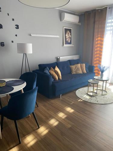 a living room with a blue couch and a table at Apartament blisko stacji kolejowej in Mińsk Mazowiecki