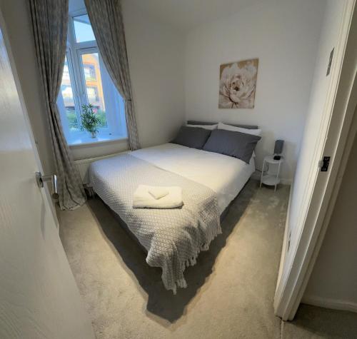 a bedroom with a bed with two towels on it at 2 Bed House near Canary Wharf in London