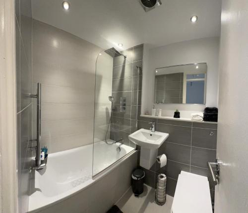 a bathroom with a tub and a sink and a shower at 2 Bed House near Canary Wharf in London