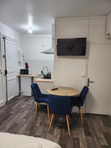 une cuisine avec une table et des chaises dans une pièce dans l'établissement Studio proche Paris, à Saint-Denis