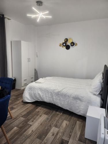 une chambre avec un lit et un ventilateur de plafond dans l'établissement Studio proche Paris, à Saint-Denis