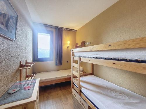 une chambre avec deux lits superposés et une fenêtre dans l'établissement Appartement cosy 2 pièces pour 5 pers., balcon sud, au pied des pistes, proches commerces - FR-1-275-168, à La Rosière