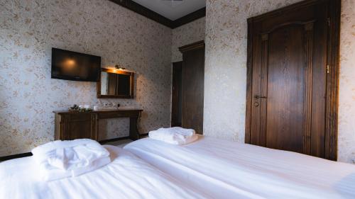 a bedroom with two beds and a tv on the wall at Nordian chalet next to Bukovel ski lift in Bukovel
