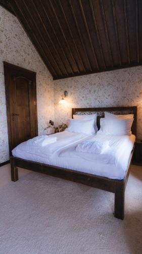 a bed with white sheets and pillows in a bedroom at Nordian chalet next to Bukovel ski lift in Bukovel